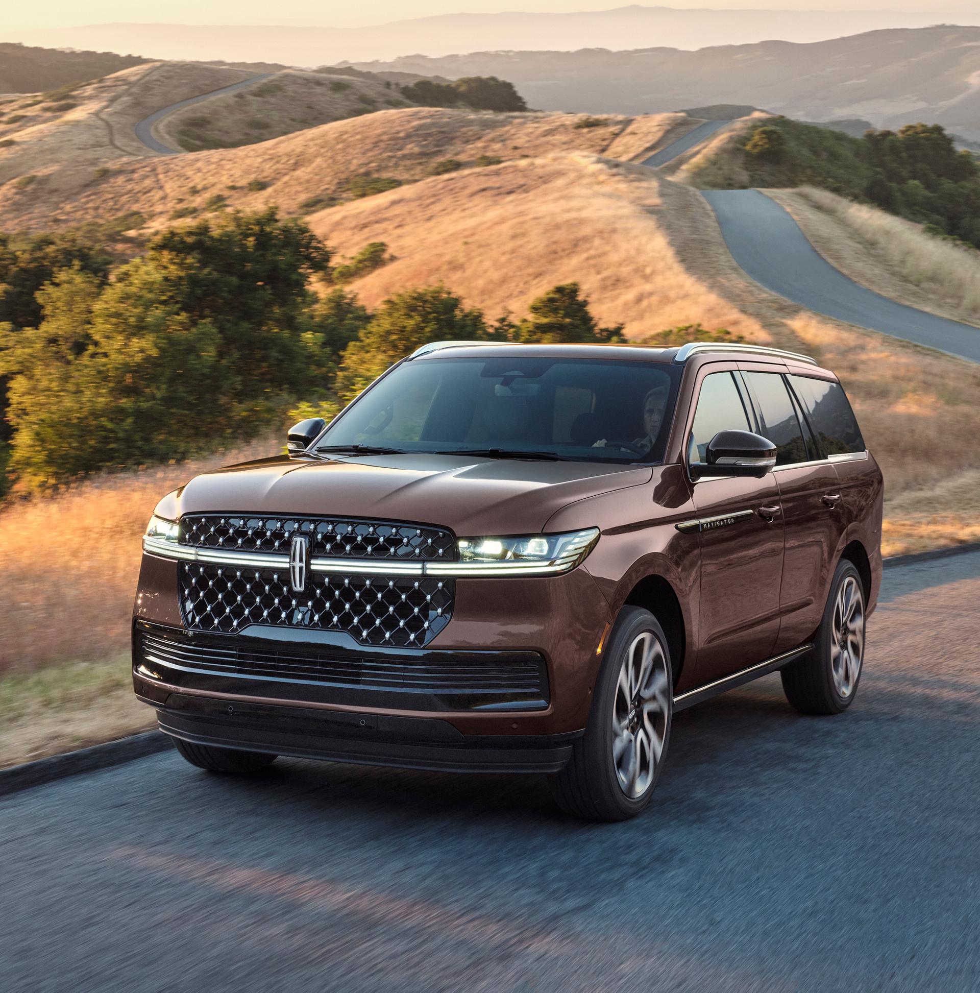 A 2027 Lincoln Navigator® Black Label™ SUV is being driven on a country road