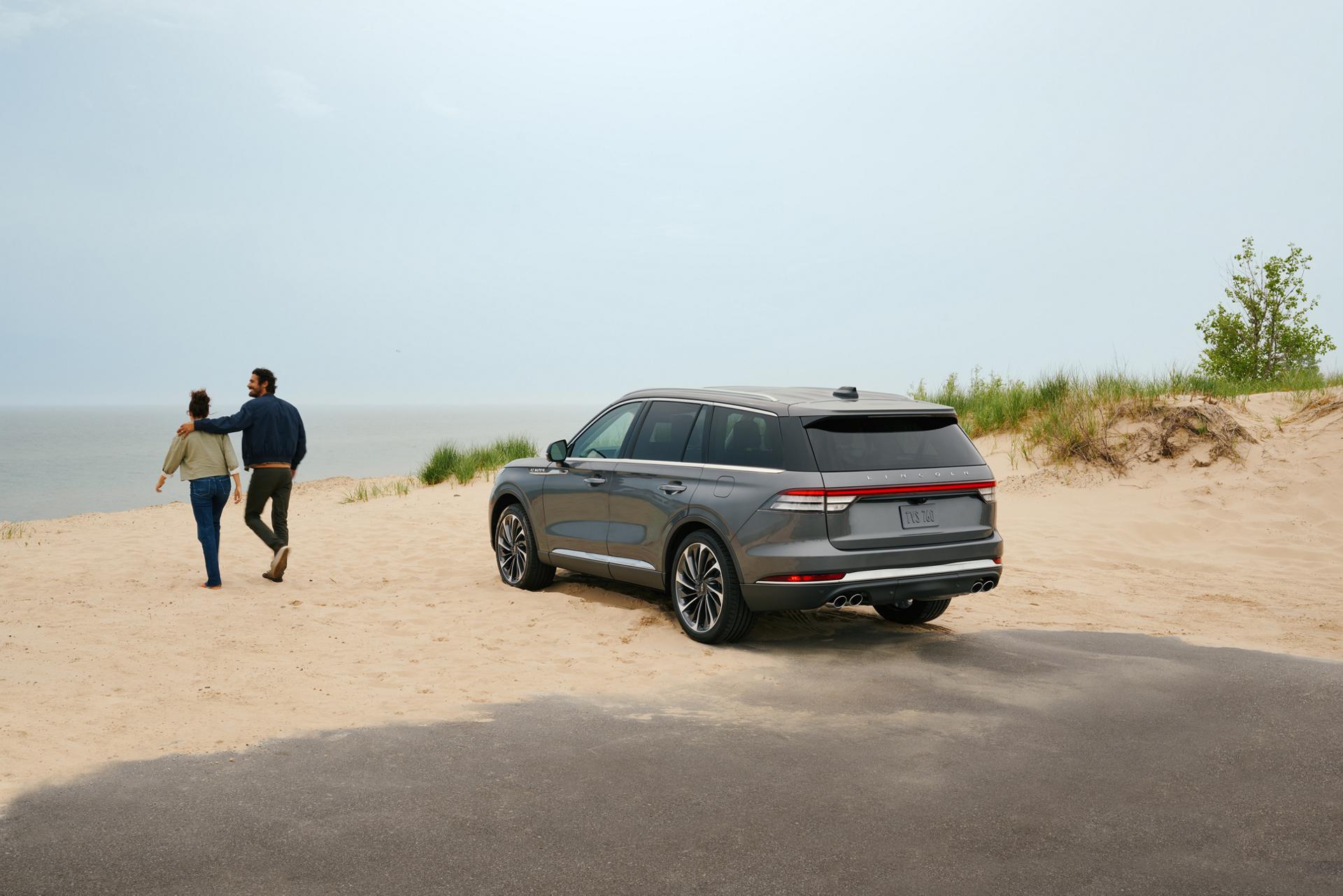 A 2027 Lincoln Aviator® SUV is parked by lake side sand dunes