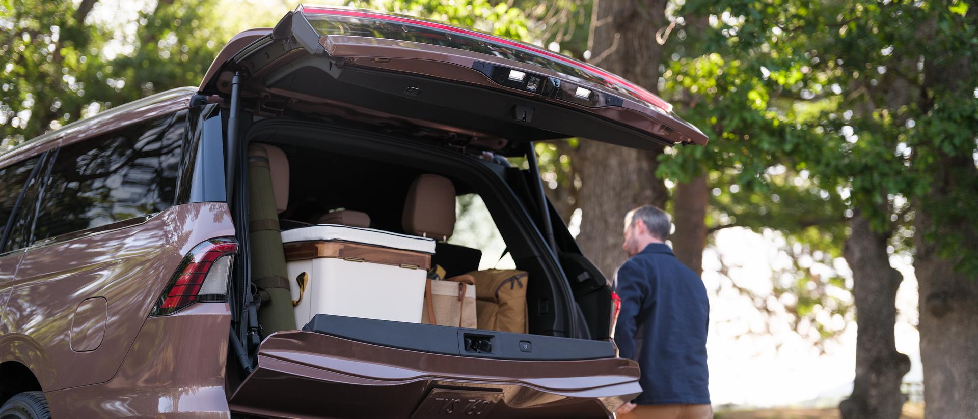 A man is walking next to the 2026 Lincoln Navigator where the trunk space is shown.