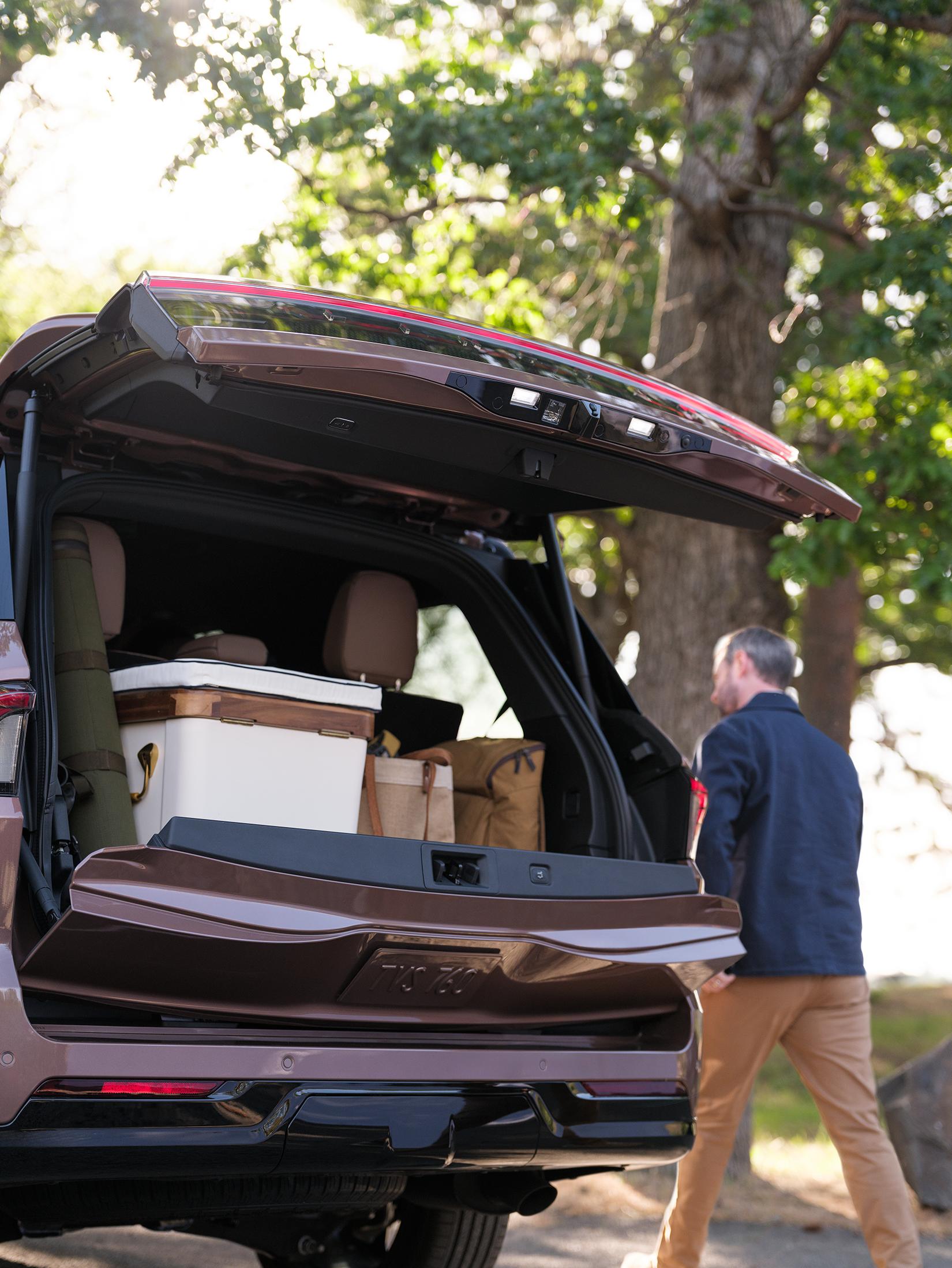 A man is walking next to the 2026 Lincoln Navigator where the trunk space is shown.