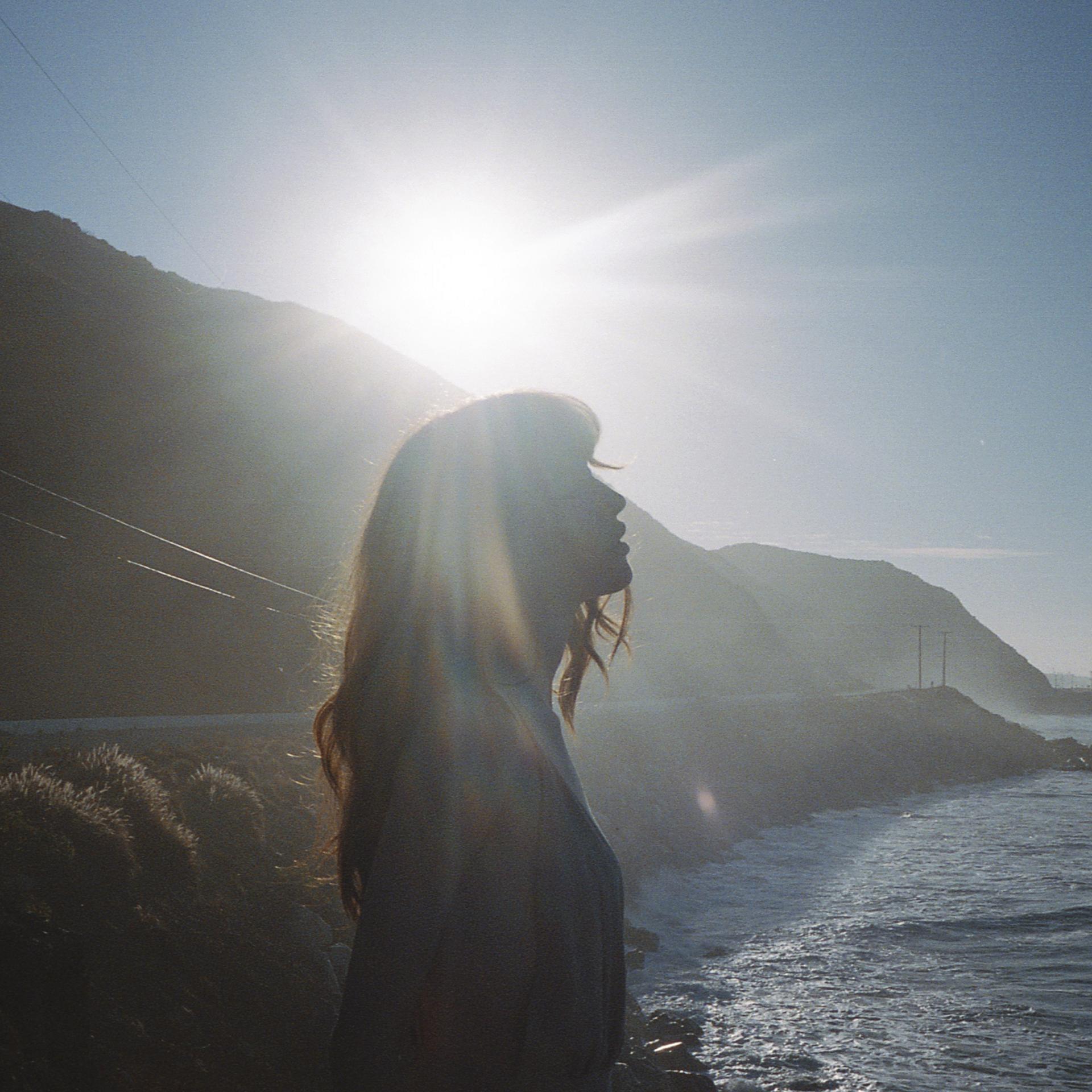 A woman enjoys a moment on a seaside overlook