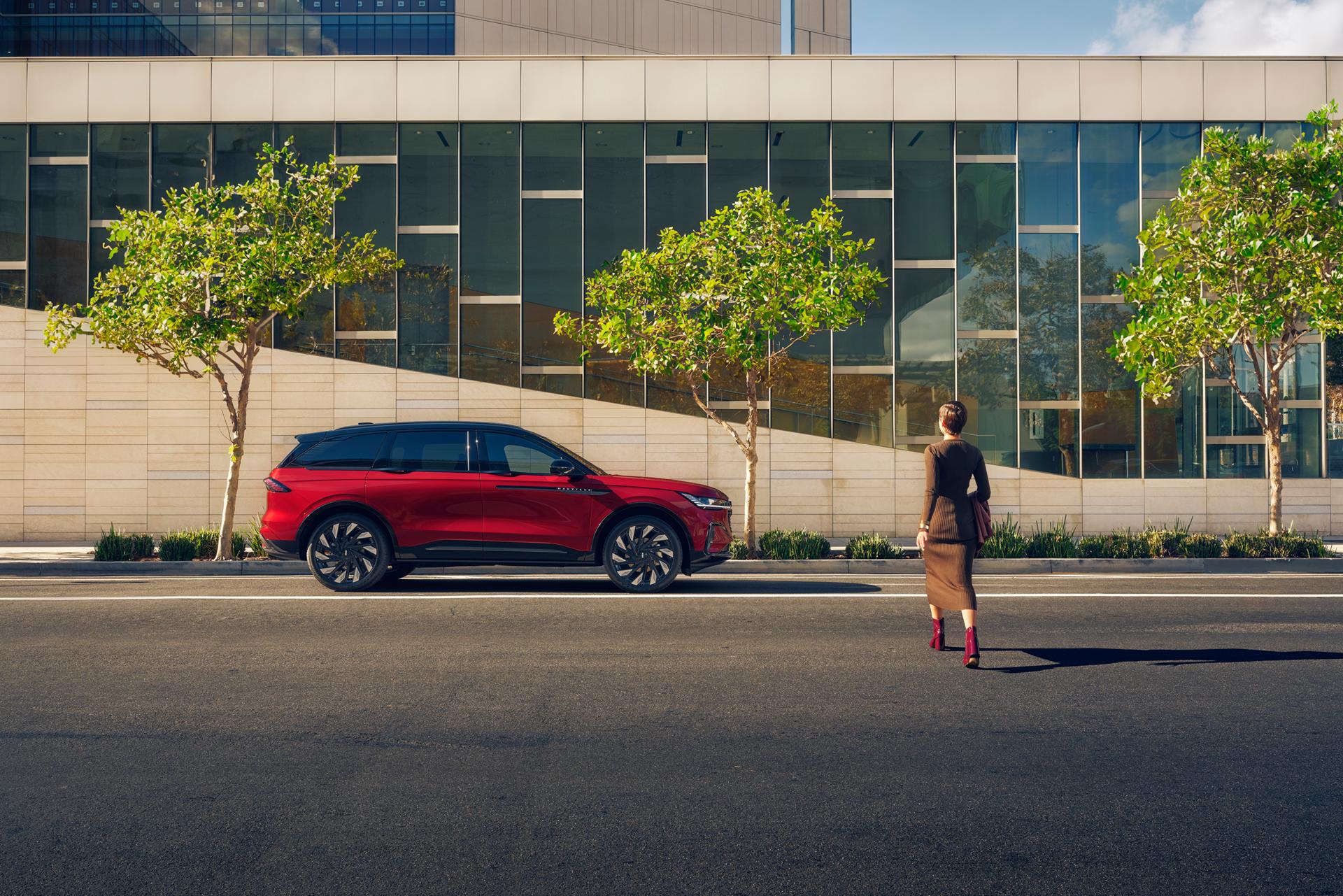 A woman crosses a city street and approaches a parked 2026 Lincoln Nautilus® SUV