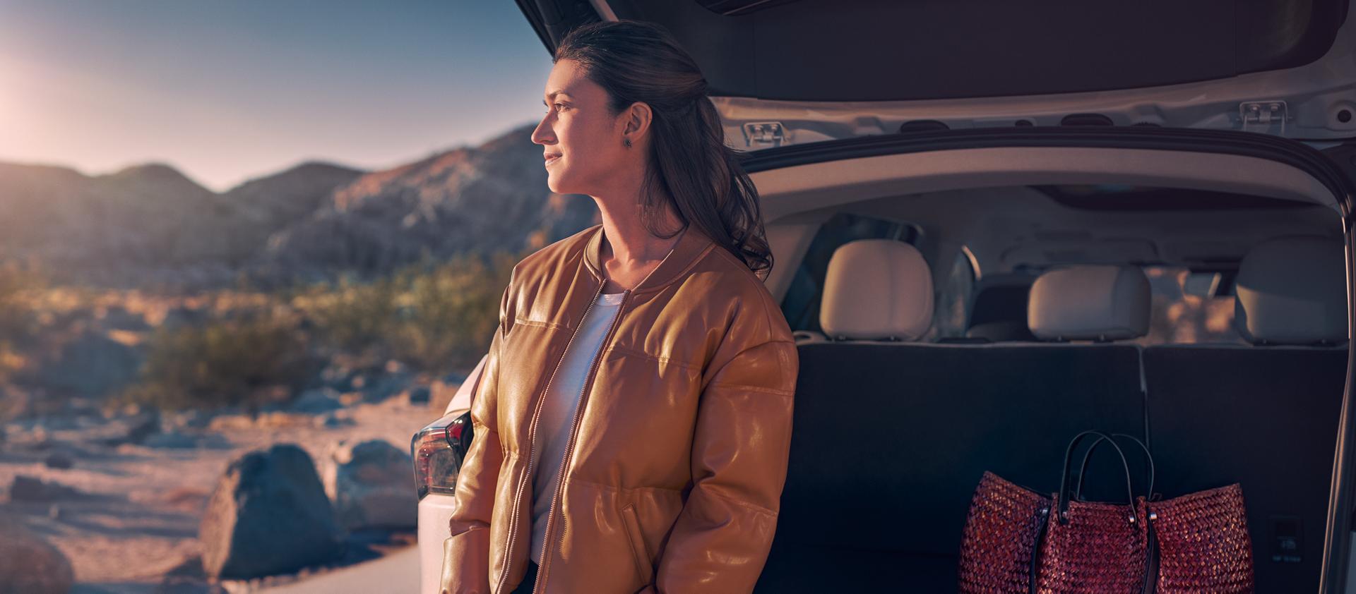 Una mujer está sentada en el área de carga trasera de una SUV Lincoln Nautilus® 2026