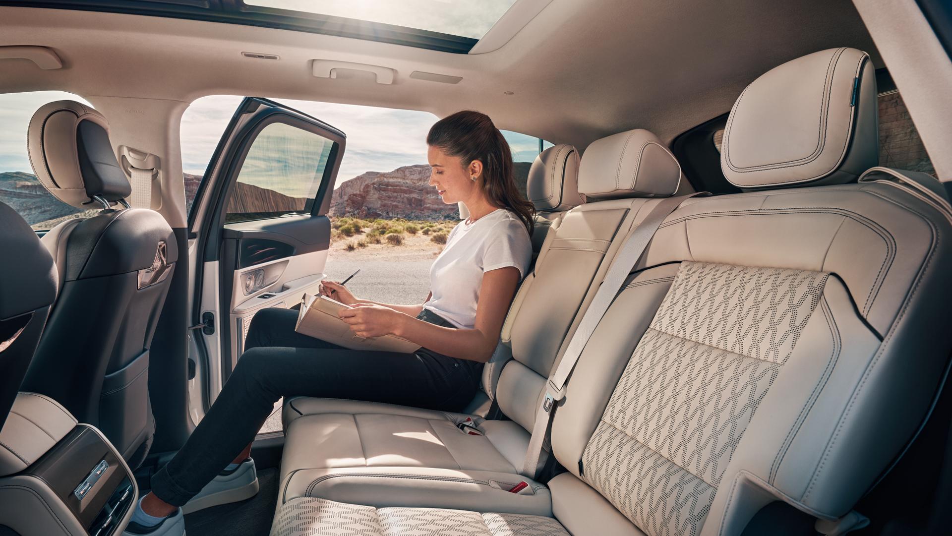 A woman sits comfortably in the spacious second row of a 2026 Lincoln Nautilus® SUV