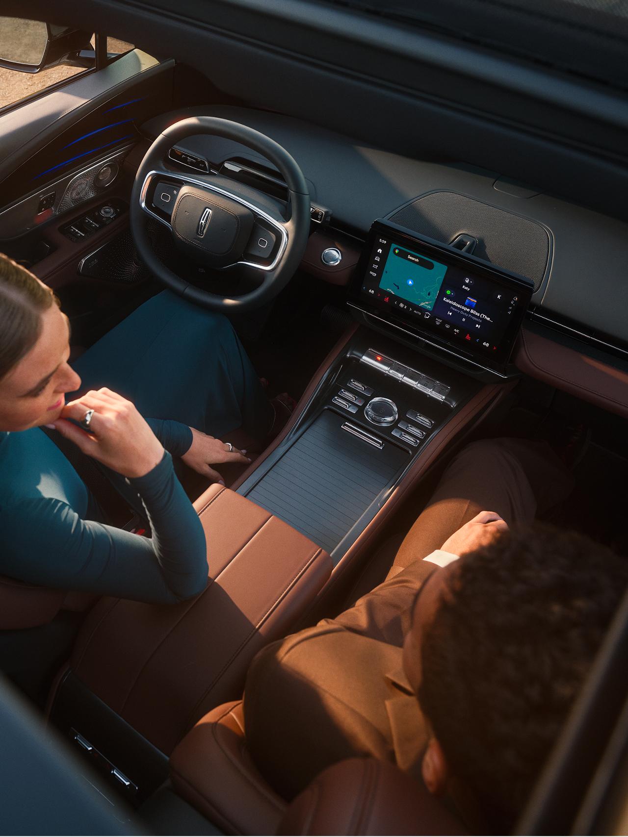 Hand tapping the Lincoln center touchscreen to access vehicle software settings.
