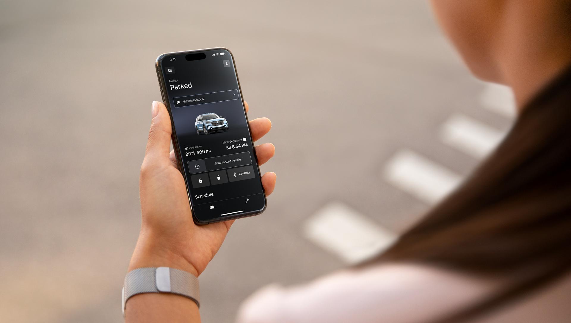 A hand holding a phone and on it is the Lincoln app