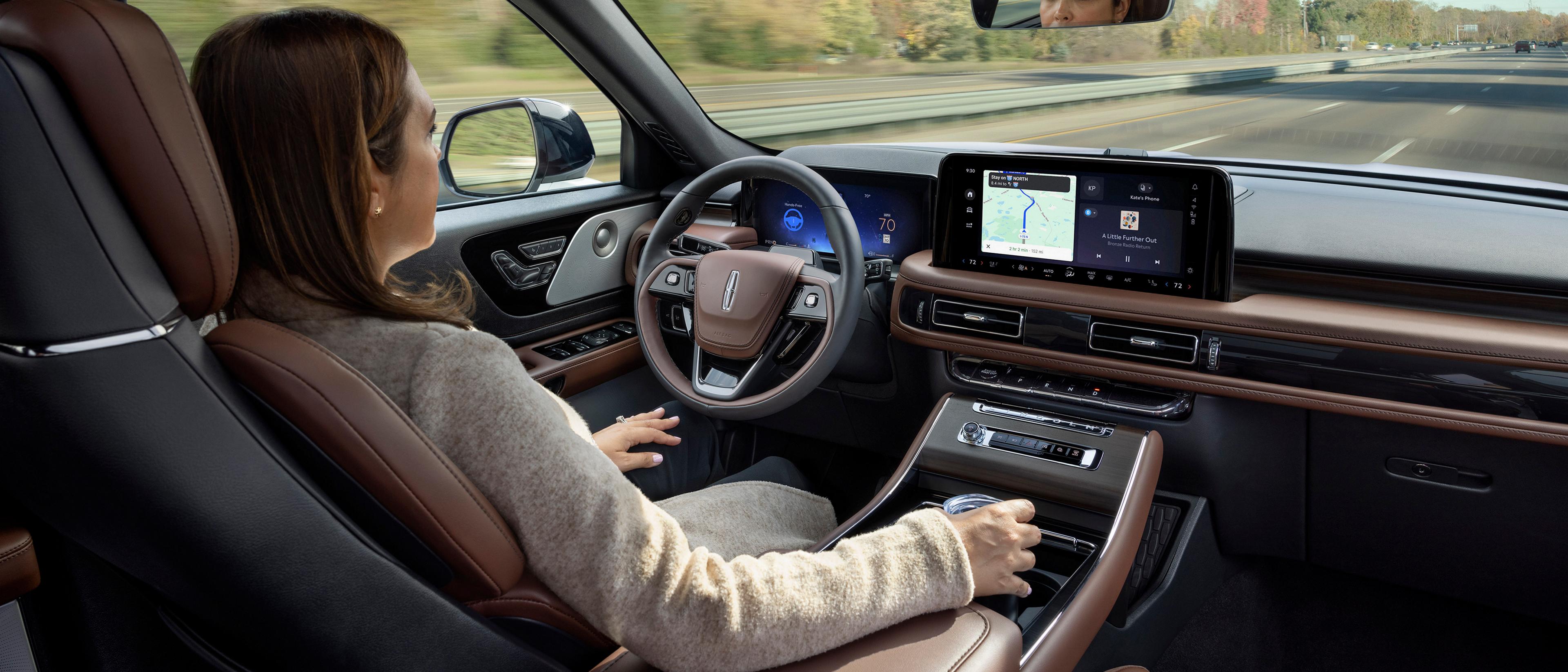 Una mujer utiliza la SUV Lincoln Aviator® 2026 con manos libres y con la vista en la carretera mediante Lincoln BlueCruise
