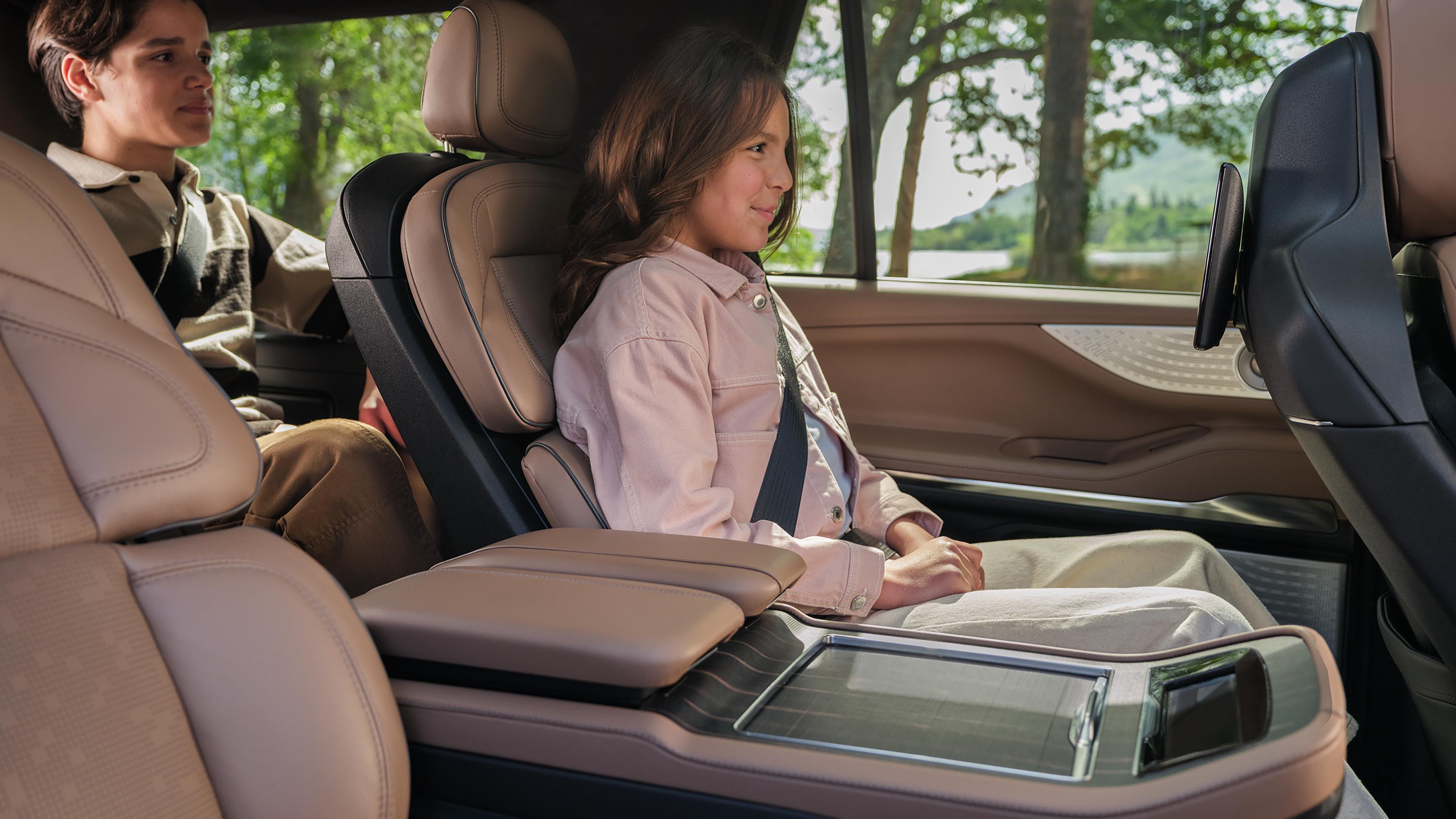 Child uses the button on the Second-Row Power Tailored seat to let a person out of the third row in a 2026 Lincoln Navigator®