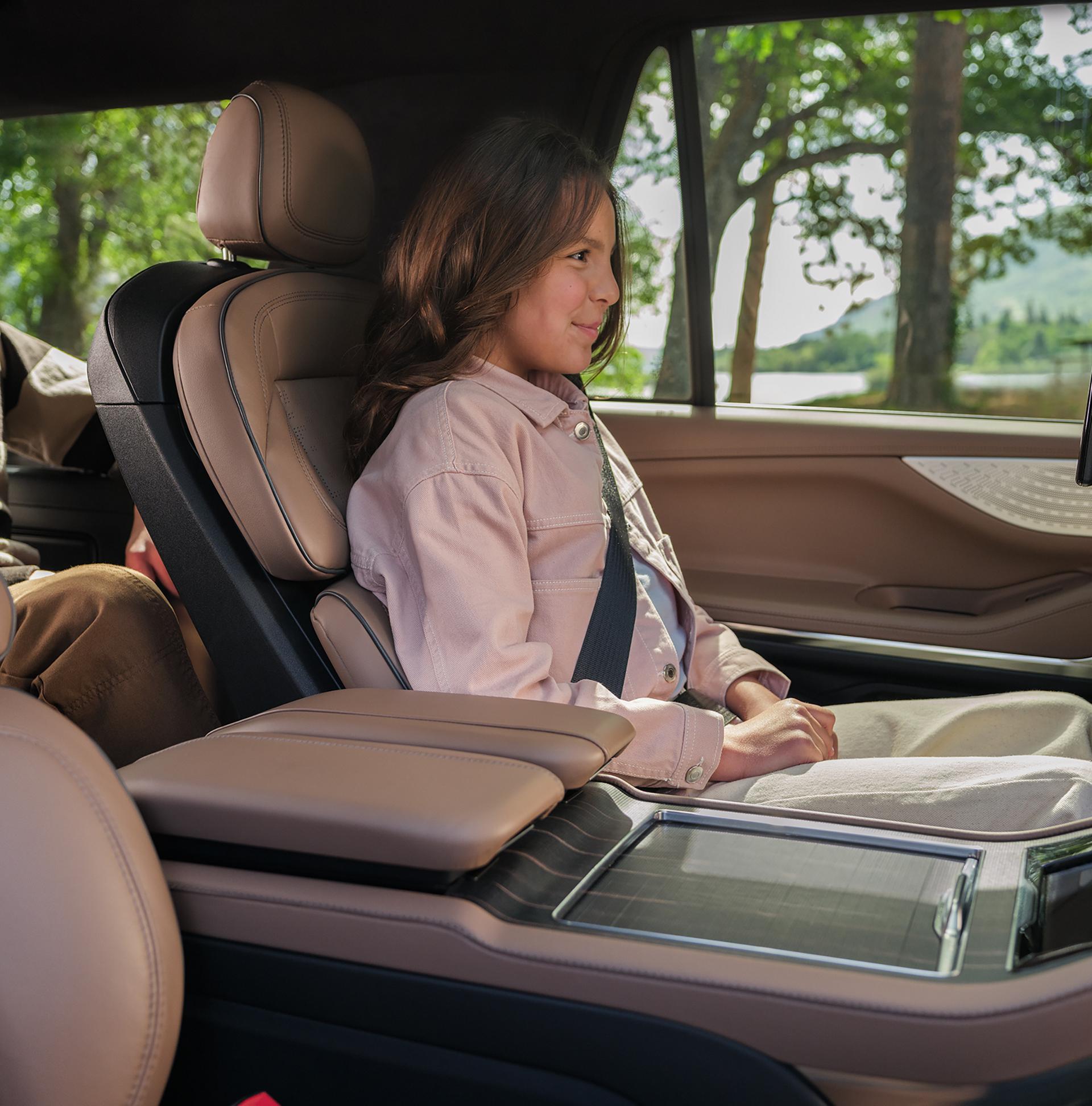 Child uses the button on the Second-Row Power Tailored seat to let a person out of the third row in a 2026 Lincoln Navigator®