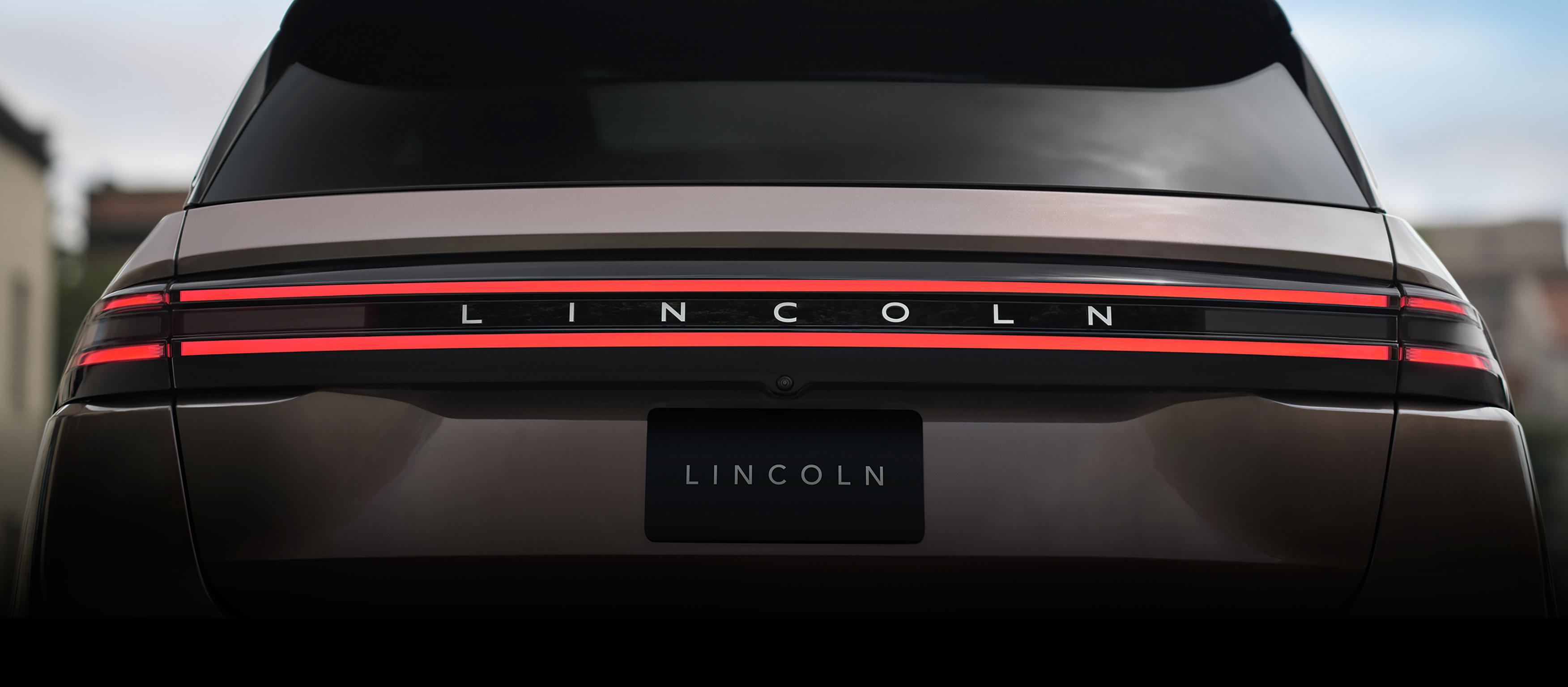 La barra de luces traseras iluminada y el emblema Lincoln brillante definen la parte trasera de una SUV Lincoln Nautilus® 2027