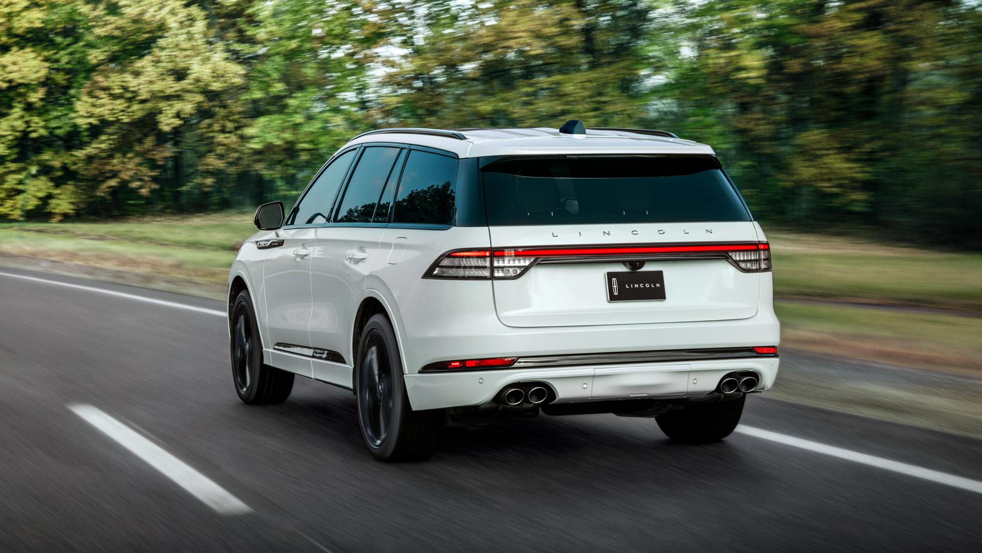 The rear of the 2025 Lincoln Aviator driving down a road.