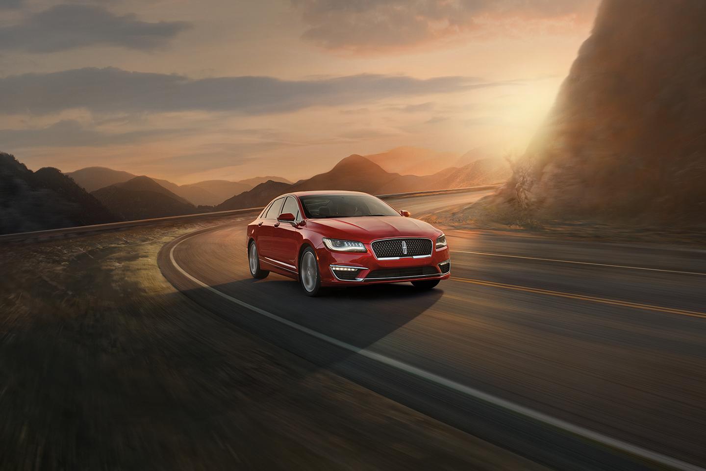 A Lincoln MKZ® sedan rounds a curve on a mountain road