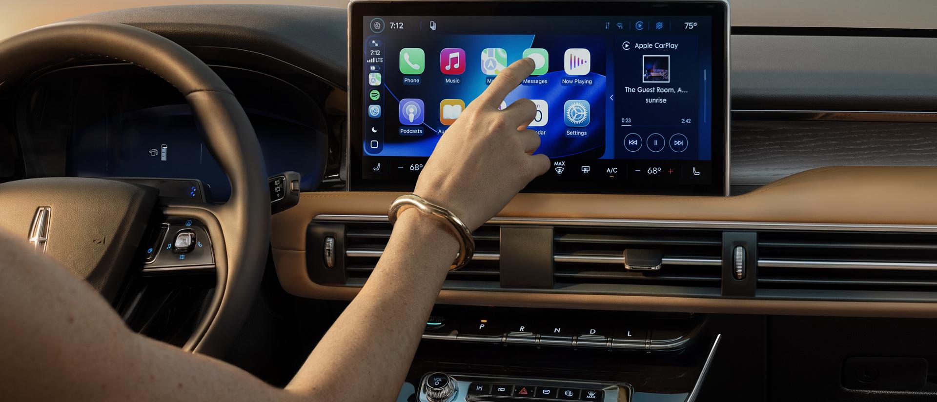 The driver interacts with the center display of a 2027 Lincoln Corsair® Hybrid