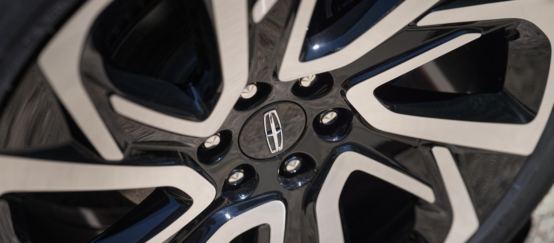The available 24-inch High Gloss Ebony Black Wheel with Bright Machined Finish on a 2027 Lincoln Navigator® Black Label™ SUV