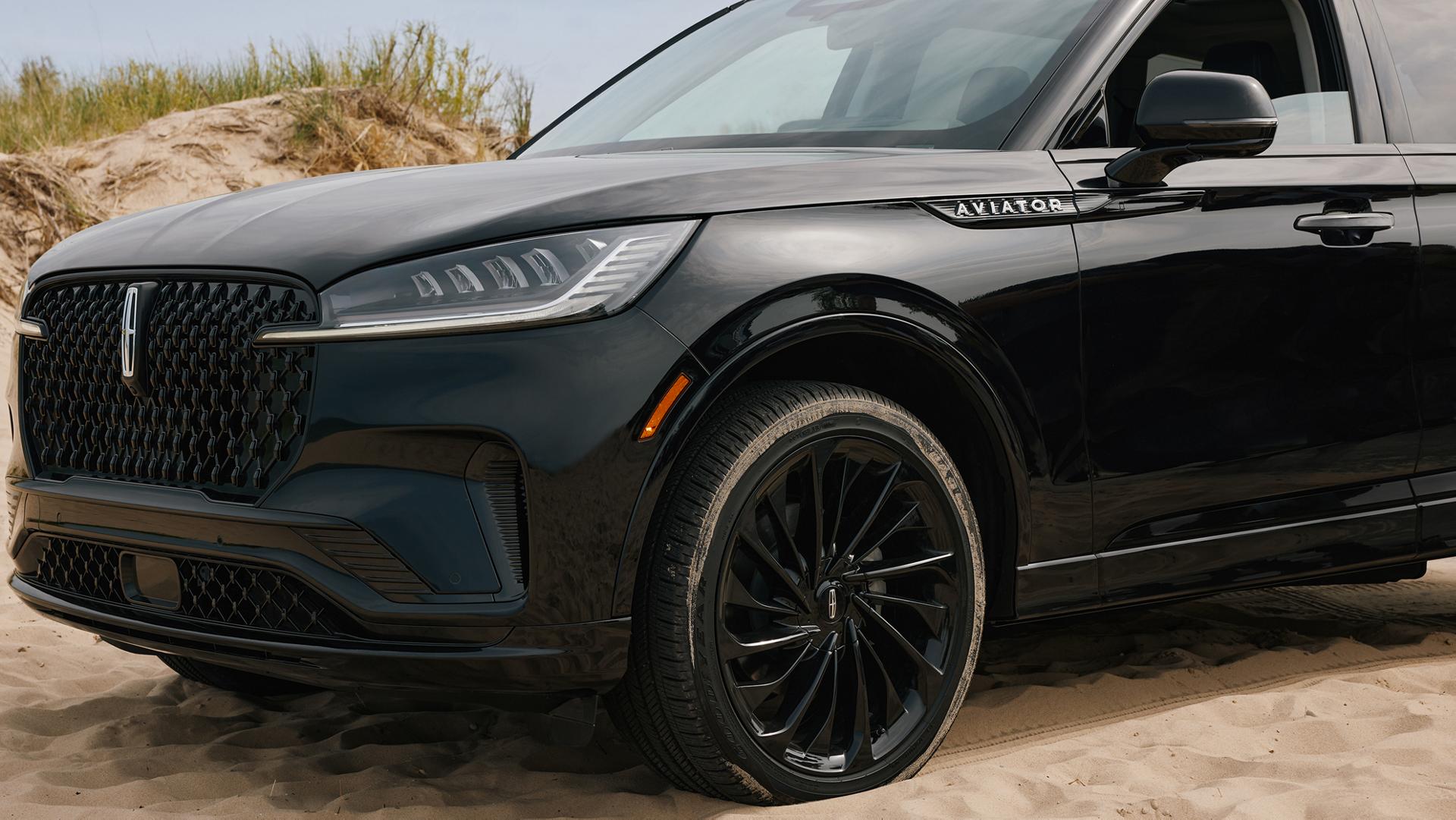 A 2027 Lincoln Aviator® SUV is parked near lakeshore sand dunes
