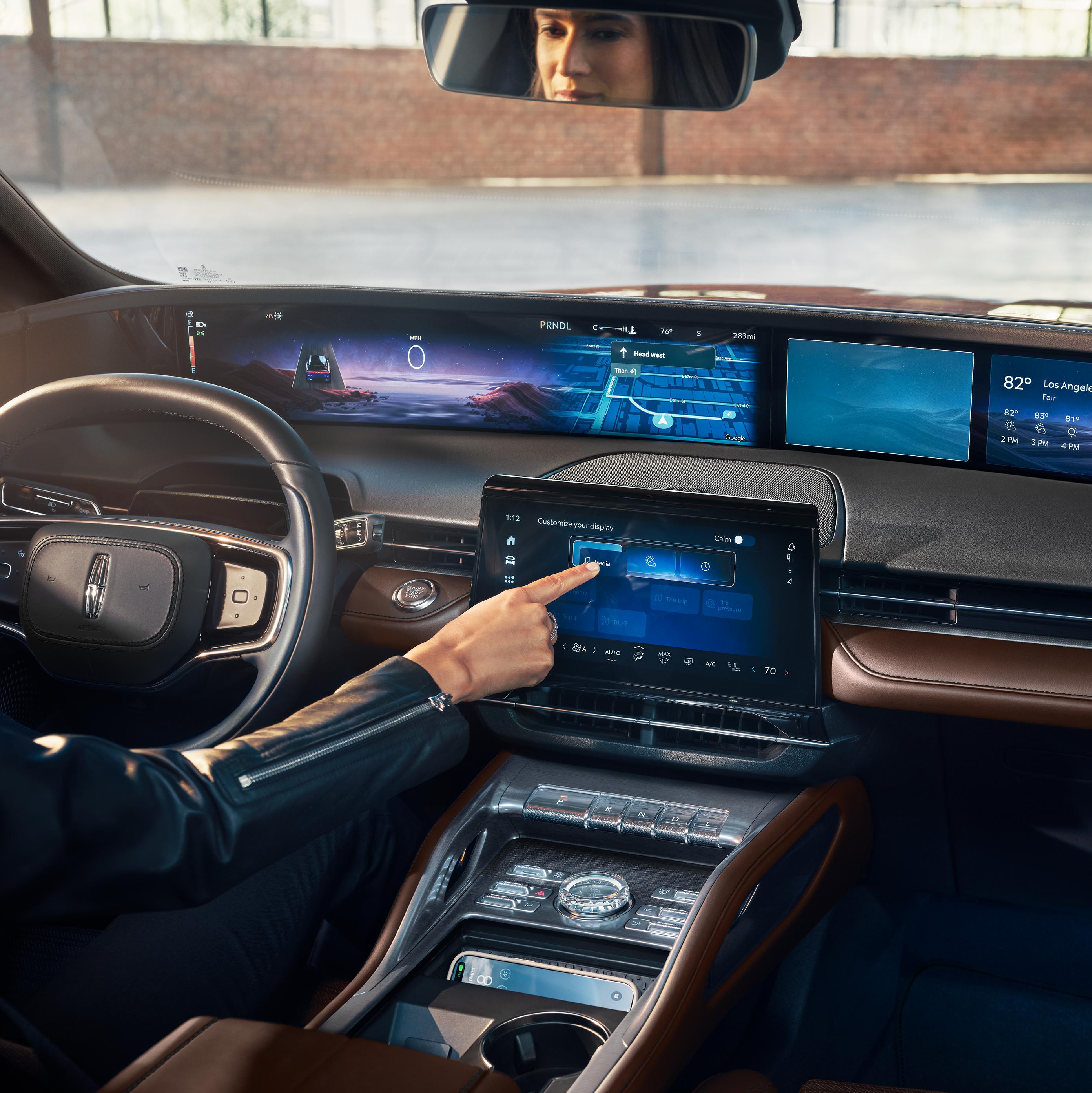 A woman interacts with the center touchscreen of a 2026 Lincoln Nautilus® SUV