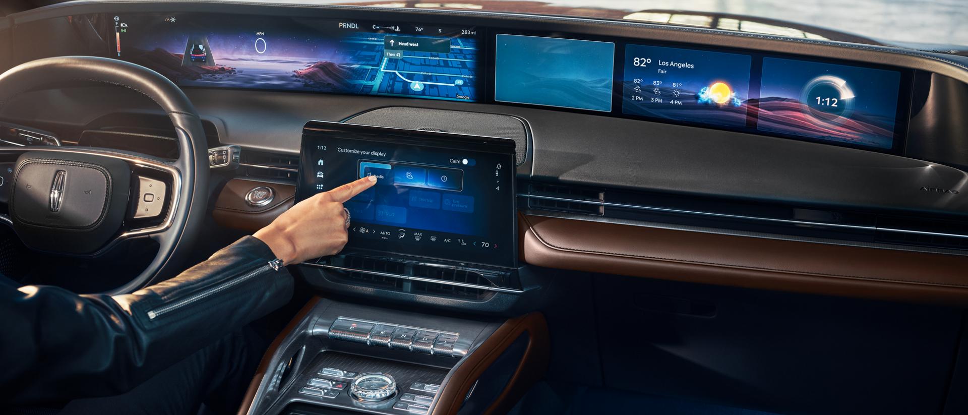 A woman interacts with the center touchscreen of a 2026 Lincoln Nautilus® SUV
