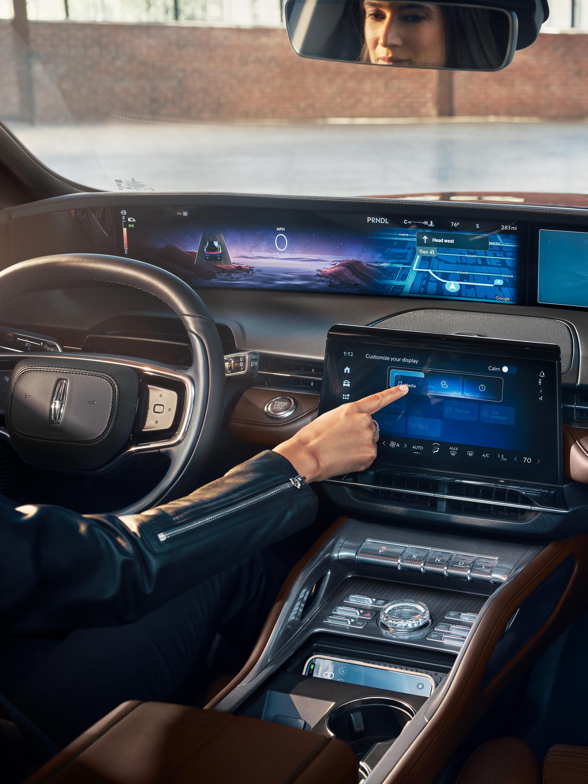A woman interacts with the center touchscreen of a 2026 Lincoln Nautilus® SUV