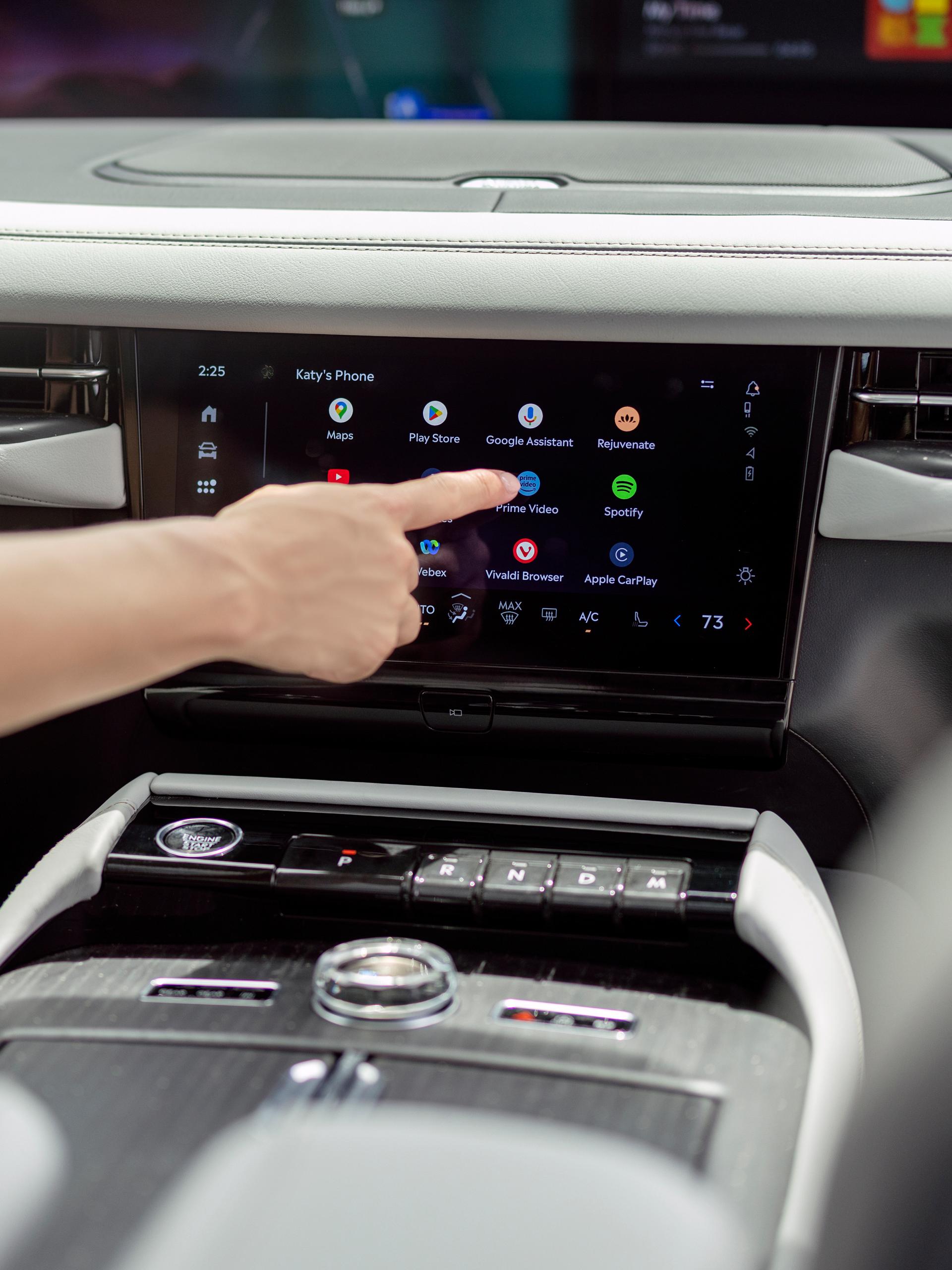 A finger presses a button on the center touch screen inside a 2027 Lincoln Navigator® SUV