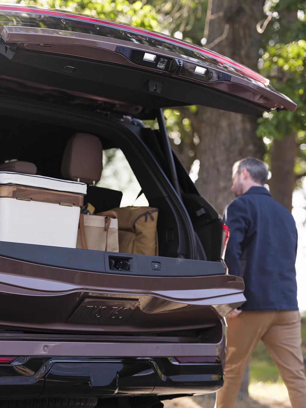 Un hombre caminando alrededor de su Lincoln Navigator 2025 mientras la cajuela está entreabierta